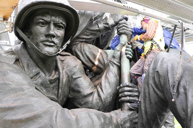 Contractors work on the sculpture