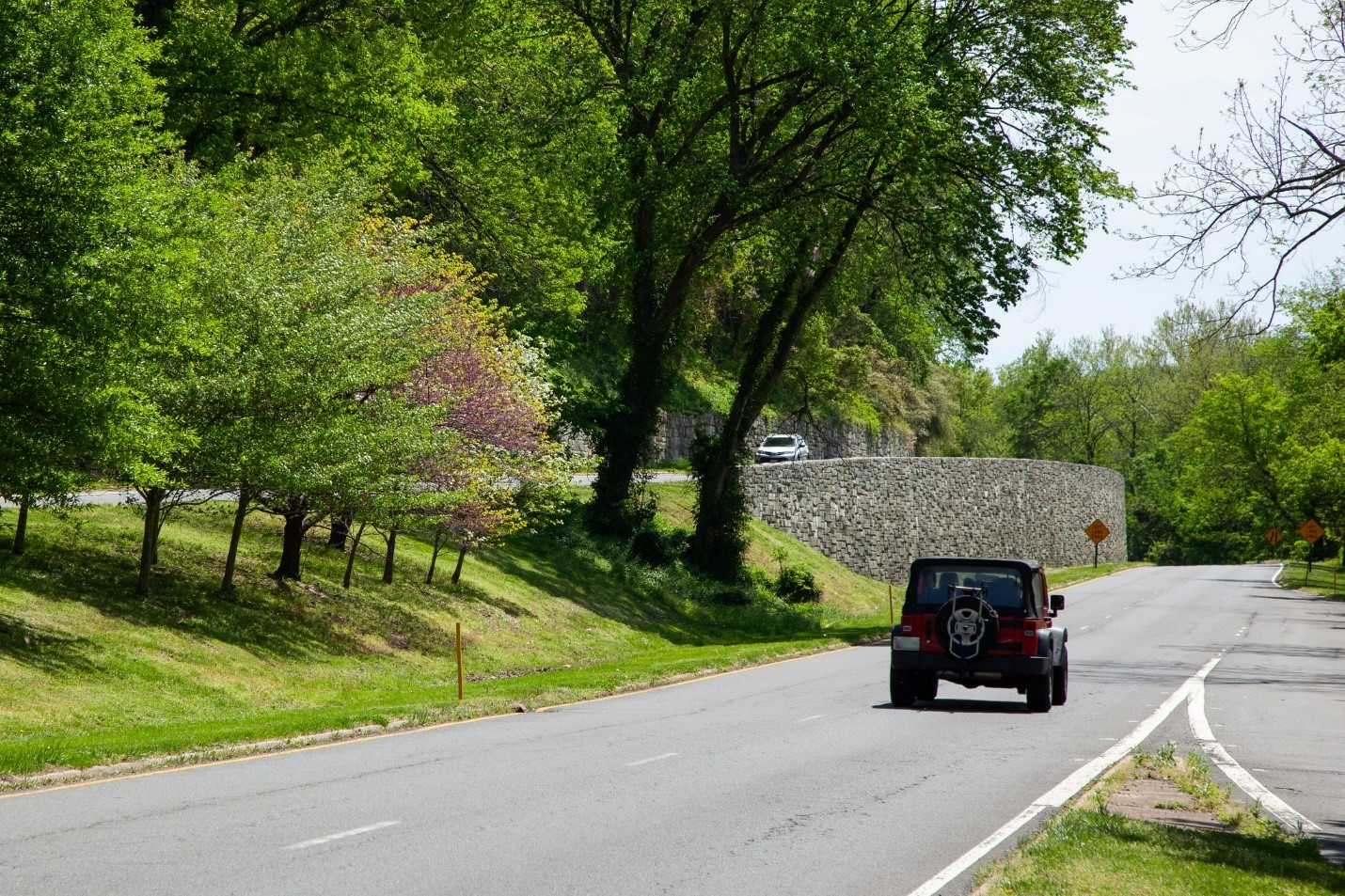 A vehicle travels along Clara Barton Parkway past retaining walls in this National Park Service photo.