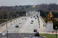 Six lanes and two sidewalks open immediately following total bridge rehabilitation. Cars drive in lanes and people walk on sidewalks.