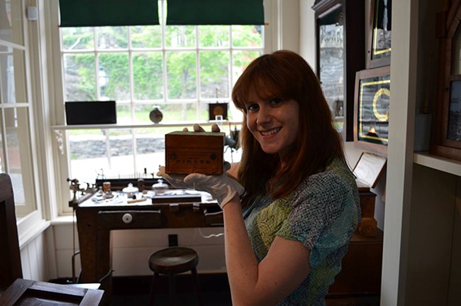 Museum Management intern, Emily, with her favorite artifact in the Burton Jewelry Store exhibit Museum Management intern, Emily, with her favorite artifact in the Burton Jewelry Store exhibit
