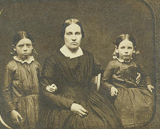 sepia tone image of a woman and two girls; from the mid-1800s