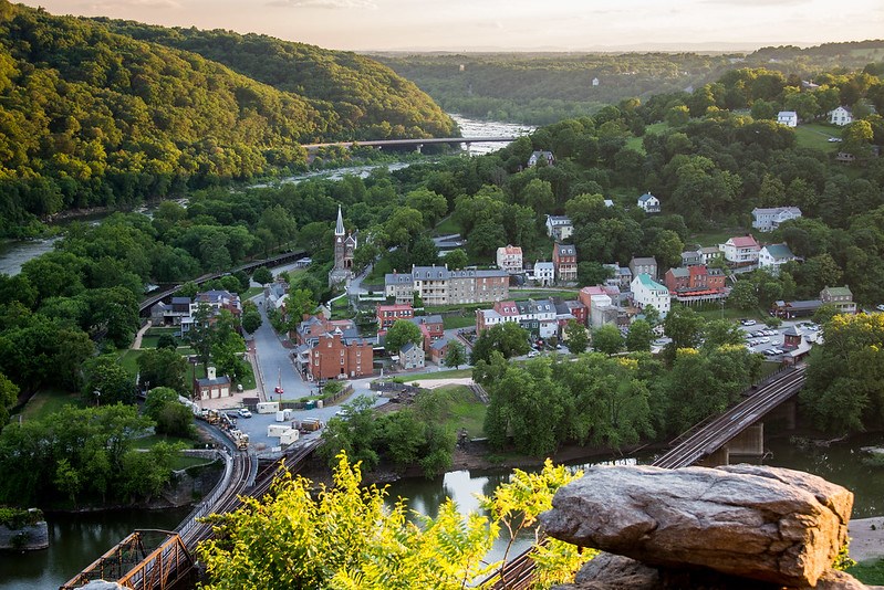 Town buildings surrounded by wooded hills, encircled by rivers.