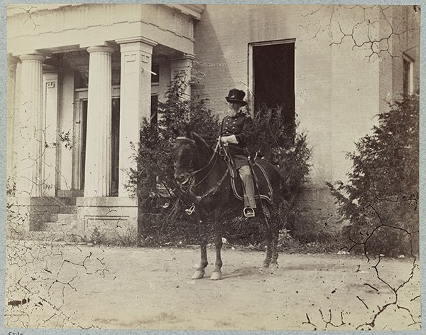 photo of Colonel Dixon S. Miles on a horse, in front of a building on Camp Hill