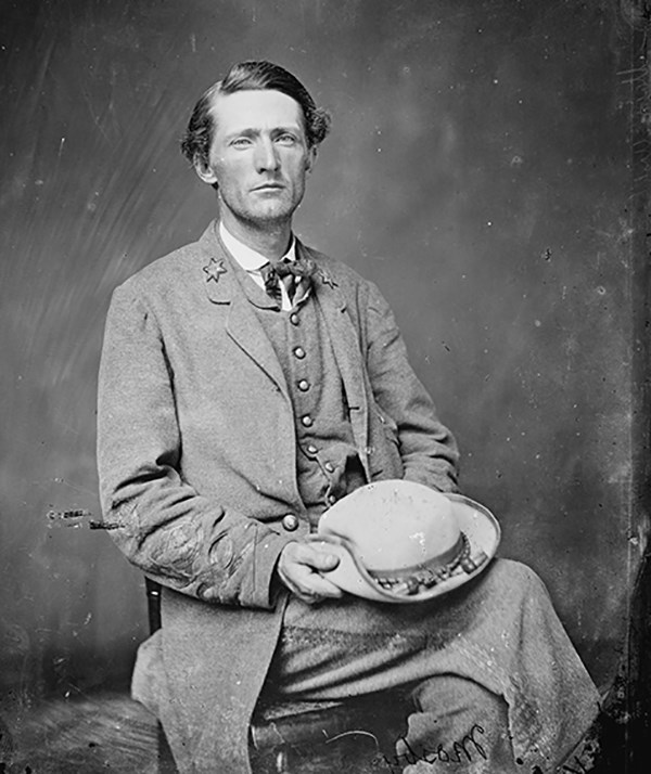 John S. Mosby seated, dressed in military uniform, posing in a photo studio