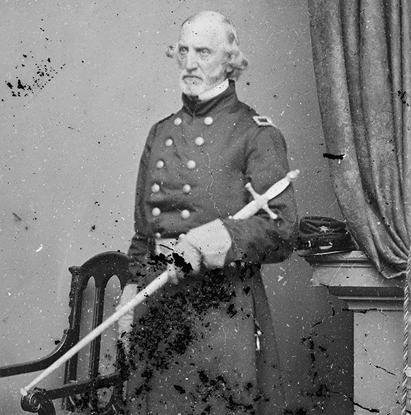 Daniel Tyler dressed in military uniform, posing in a photo studio