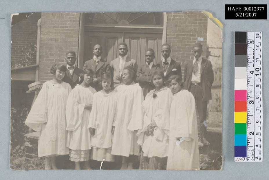 African American men and women. Men wear suits, women wear white robes.