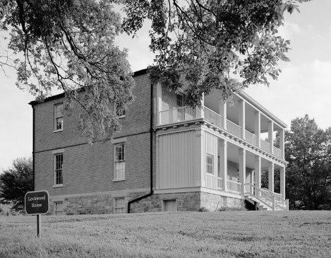 Side profile of two-story brick house with double porches.
