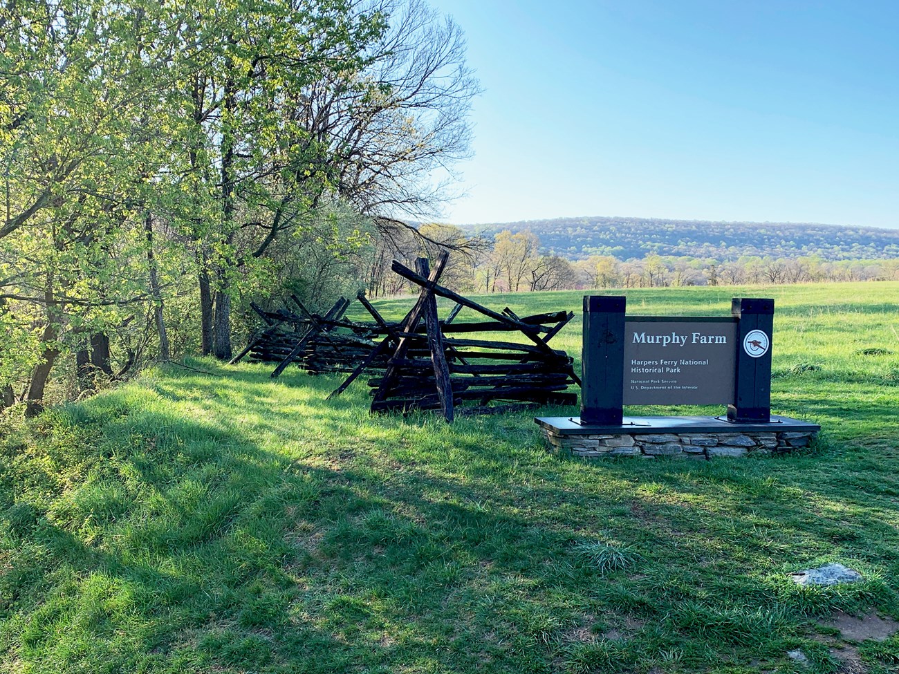 split rail fence in field with sign for Murphy Farm, Harpers Ferry National Historical Park