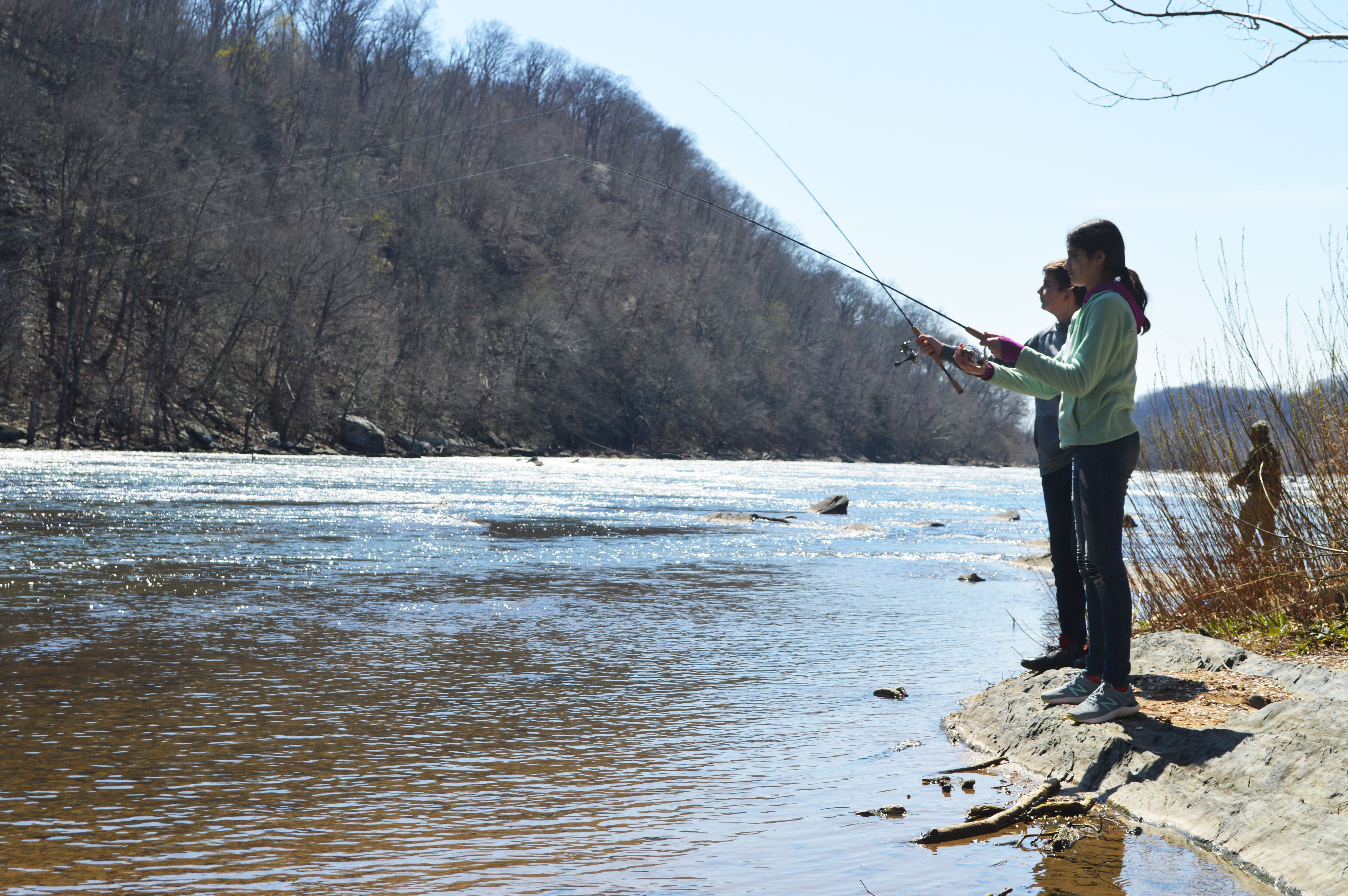Girl and boy with fishing poles on Shenandoah River banks