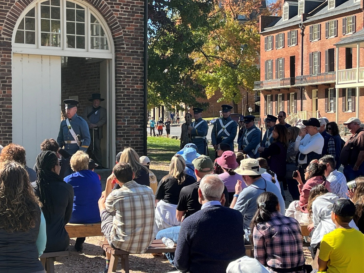 A group of people watches a demonstration by the U.S. Marine Corps Historical Company at Harpers Ferry National Historical Park.