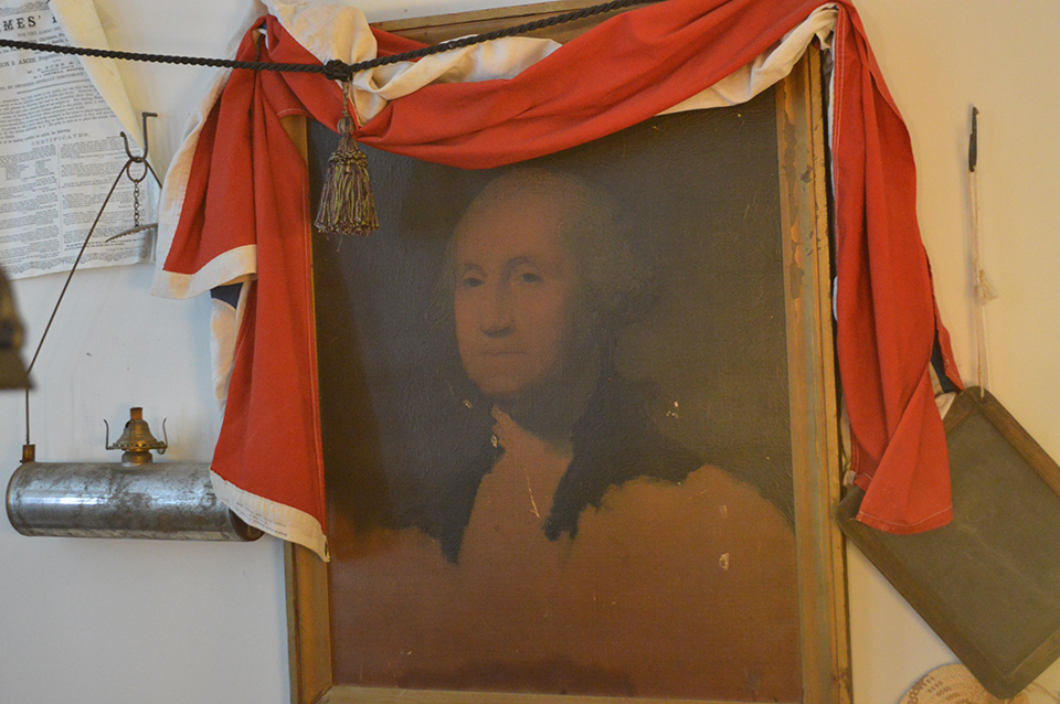 portrait of George Washington; hanging near other items in a Dry Goods Store exhibit