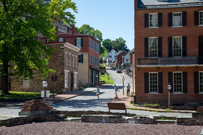 Old brick and stone buildings line a street curving uphill.