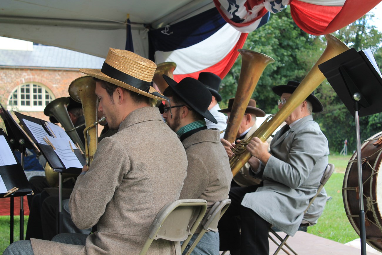 photo of men in 1860s period clothing playing brass instruments