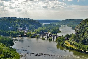 view of Harpers Ferry from Loudoun Heights in May; railroad bridges, the town, the rivers, and canal towpath are all visible in photo