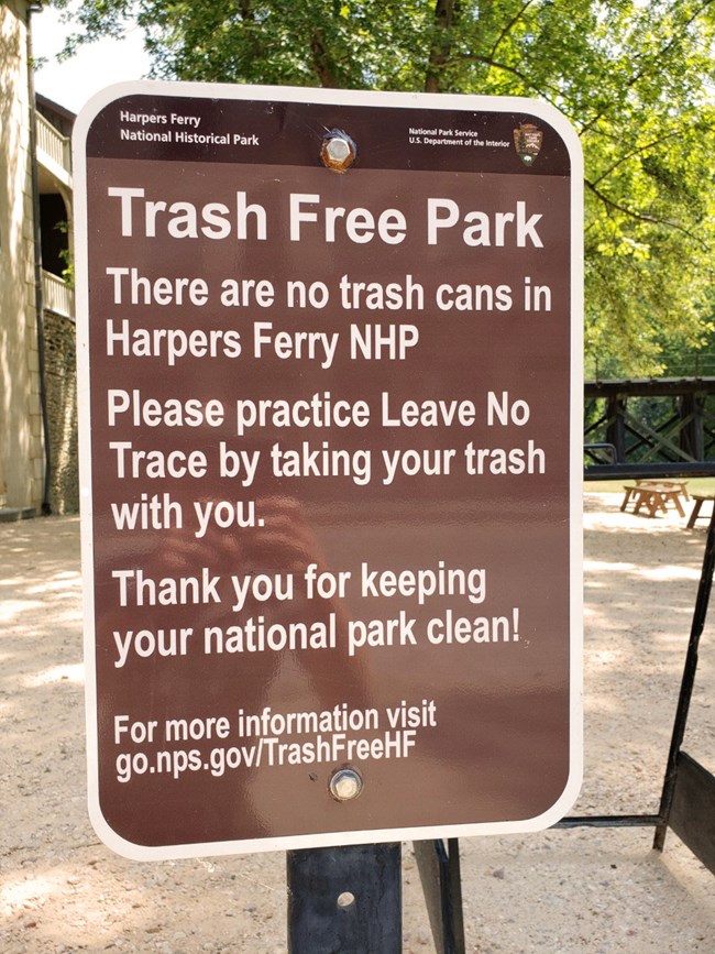 Brown and white trash free park sign