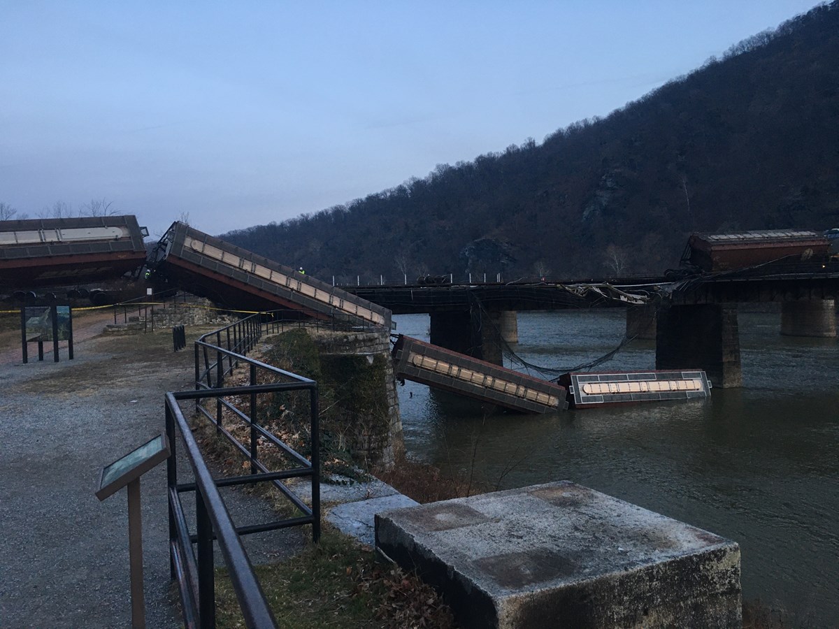 photo of train cars derailed off of a bridge into a river at Harpers Ferry