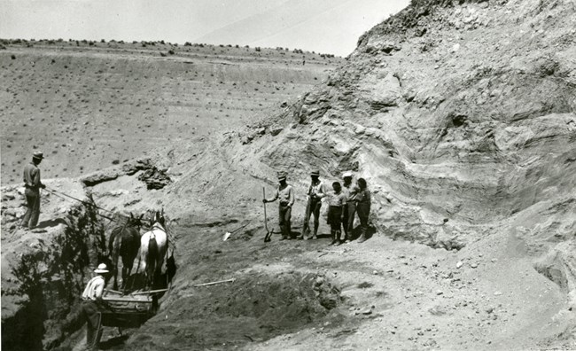 A black and white photo of the original excavation, with horses dragging a scraper through the quarry.