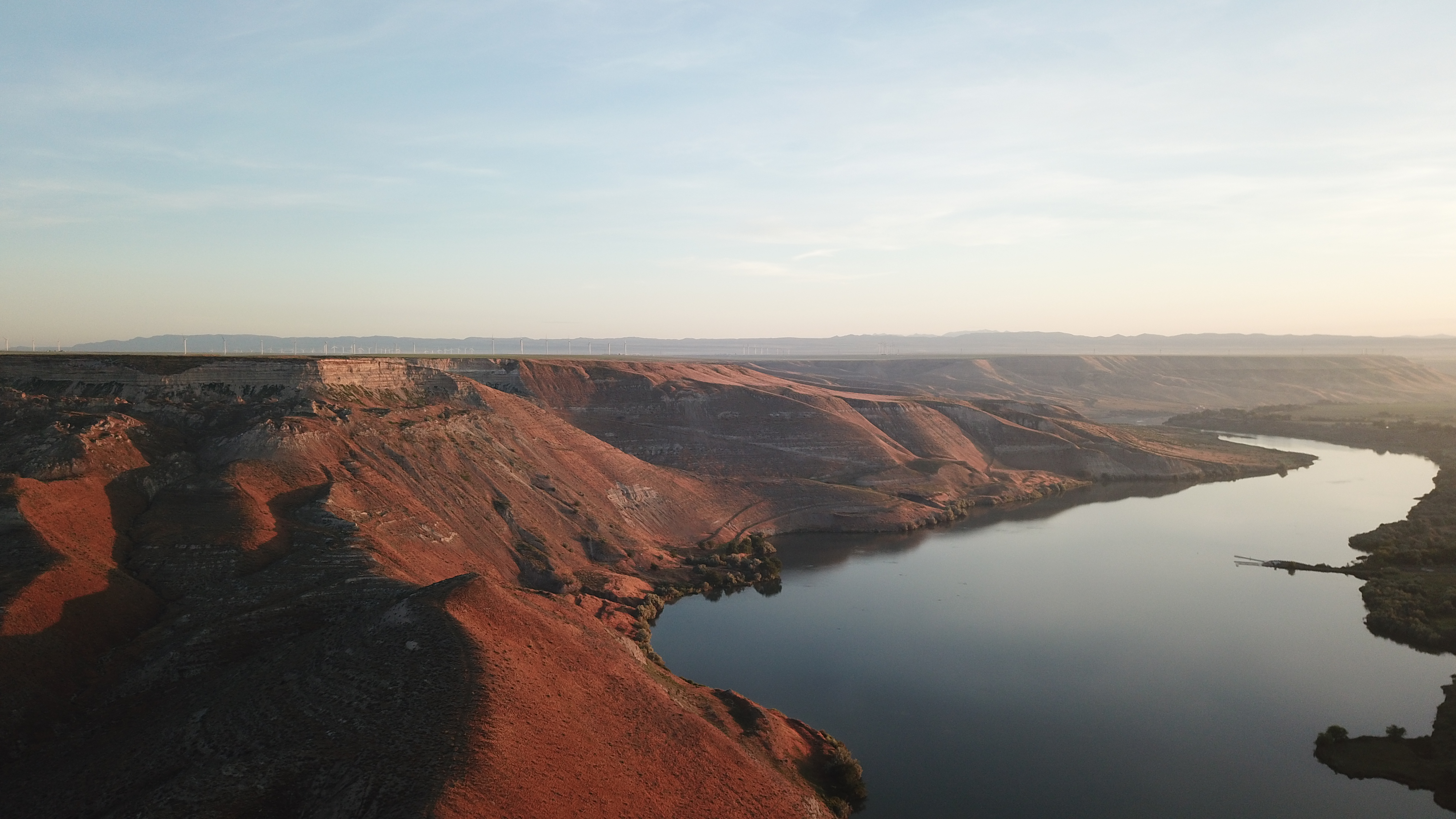 Reddish brown fossil beds slope down to the winding Snake River.