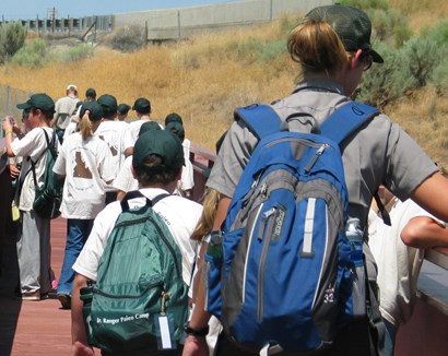 Ranger and students wearing backpacks at start of hike Ranger and students wearing backpacks at start of hike