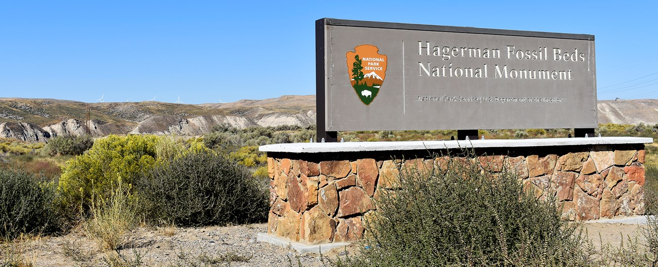 A wide sign on the side of the road reads Hagerman Fossil Beds National Monument.