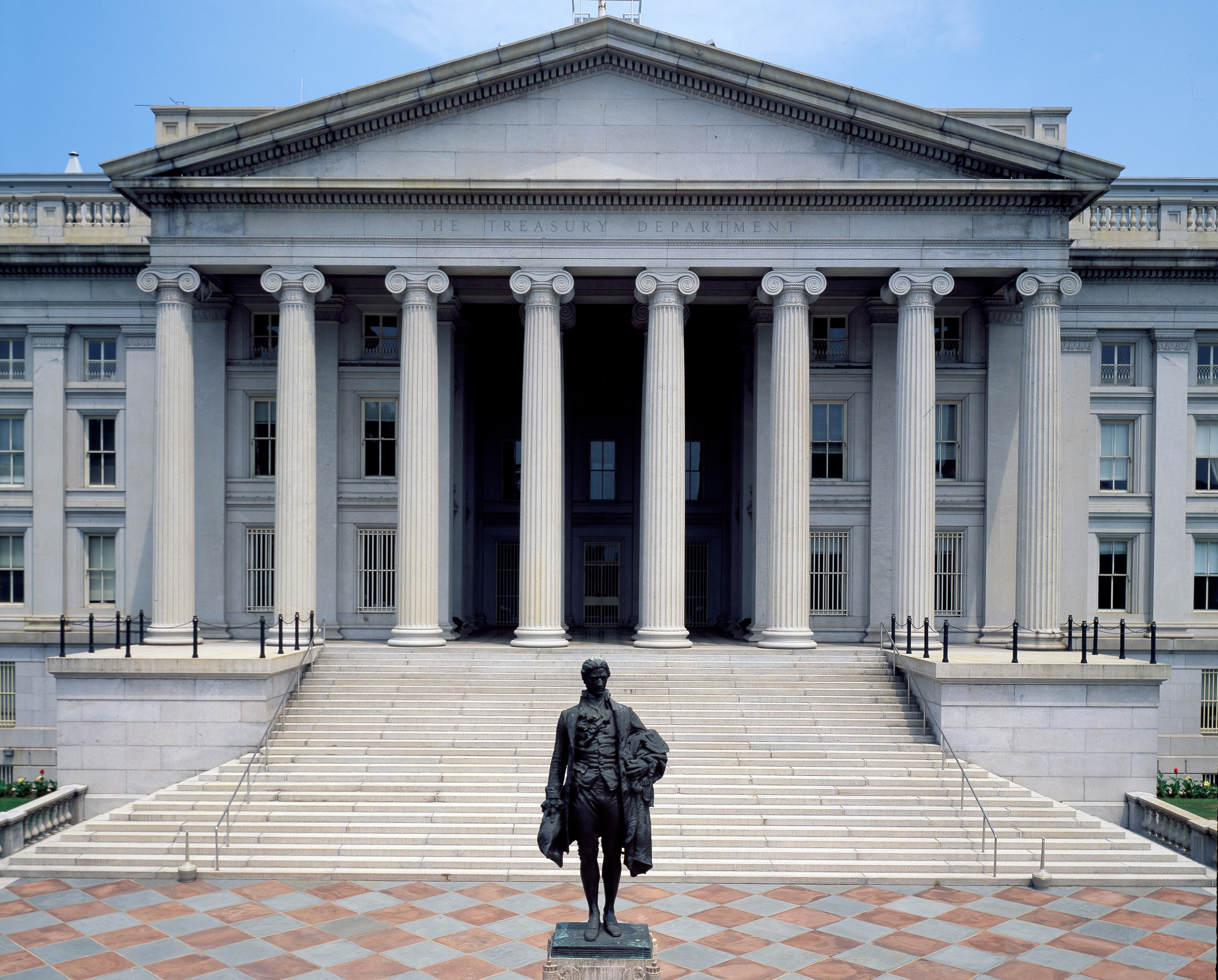A building with columns and a statue in front.