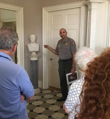 A park ranger discusses a marble bust of Hamilton in the front hall of The Grange.