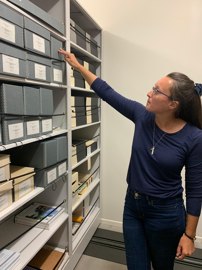 women points to box on shelve