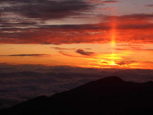 Red and orange sunrise over the ridges of the crater valley.