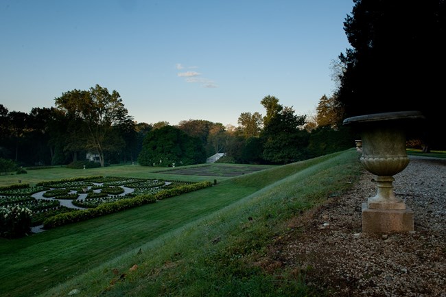 A view of the Hampton gardens with the greenhouses and caretaker's cottage in the background.