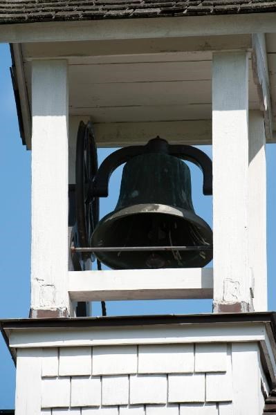 A close up view of the bell on top of the lower house.