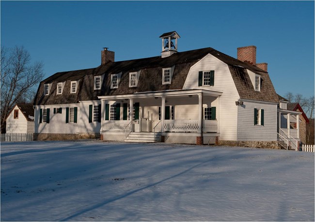 A modern day photograph of the lower farm house in the snow.