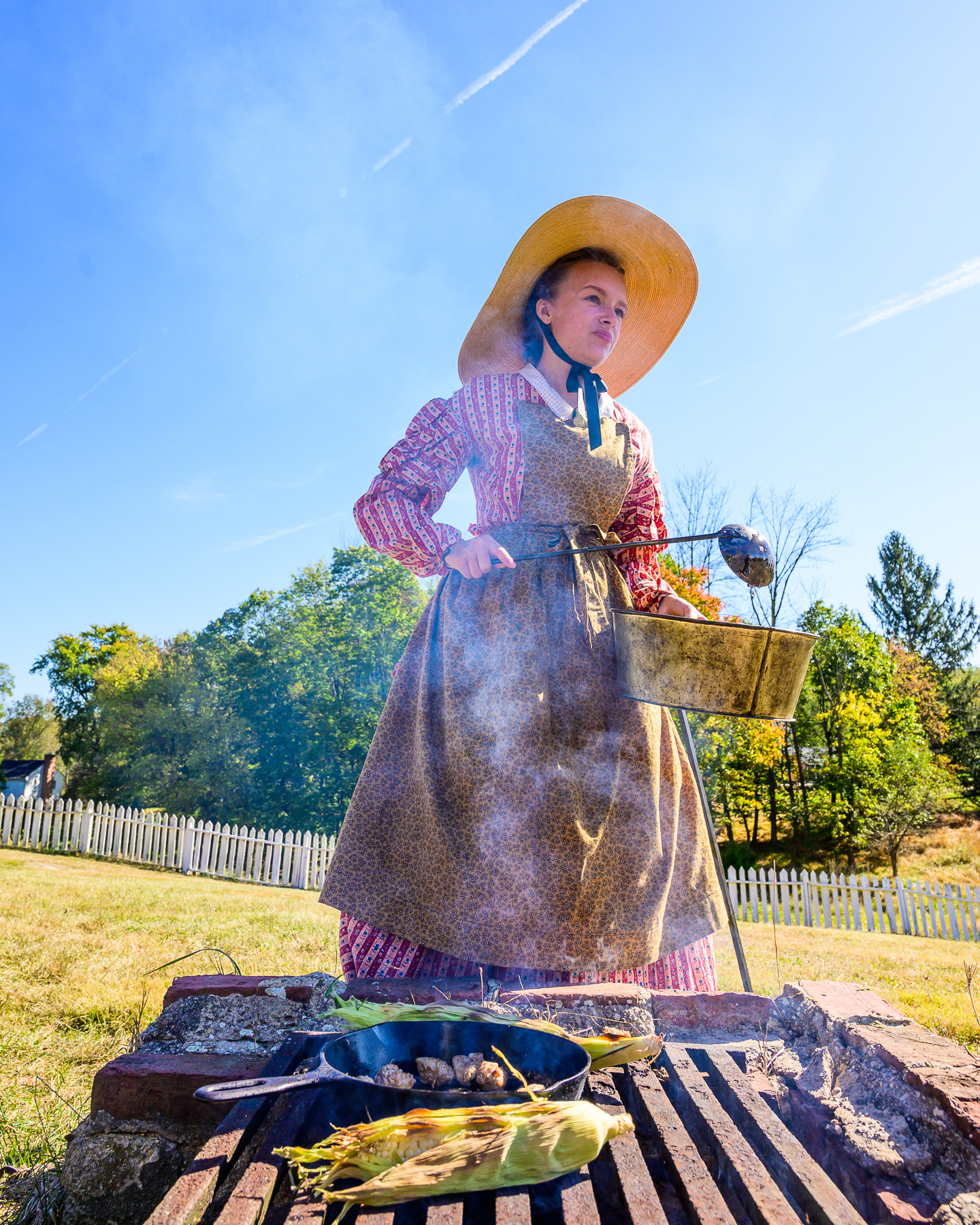 A living historian demonstrates outdoor cooking.