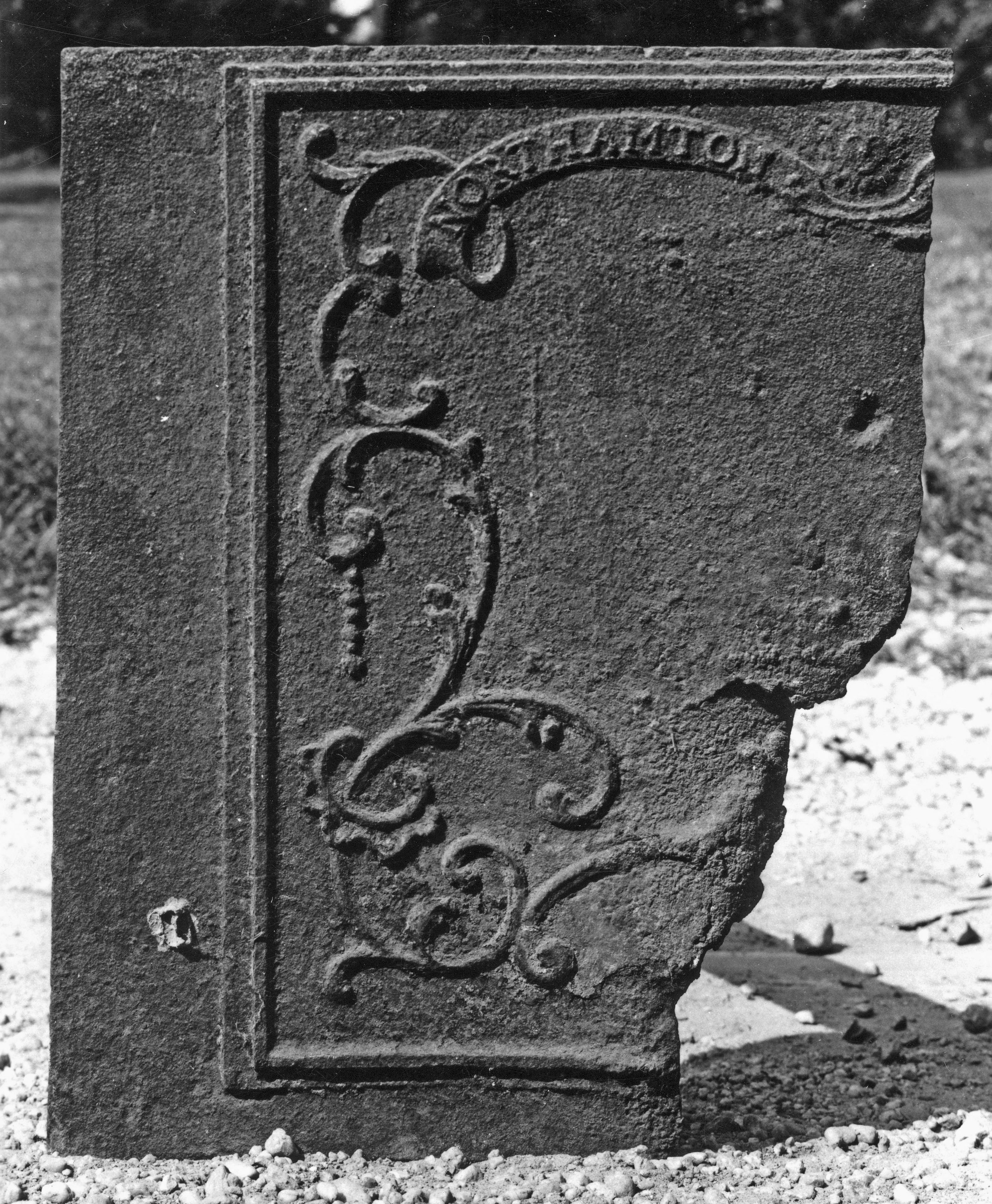 A black and white photo of a piece of a fireback.