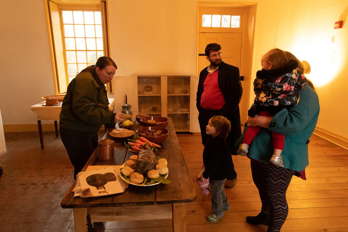 A ranger showing a family the Hampton kitchen.