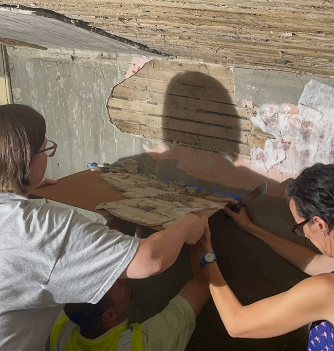Removing Historic Plaster Conservators remove a large section of plaster from a wall using a rigid board for support