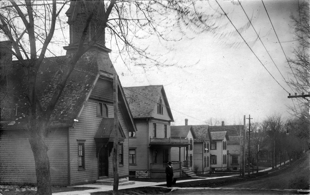 Black and white historic photo of Parker Street in Auburn, New York. 1913. The Thompson AMEZ Church is on the far left, parsonage next door.