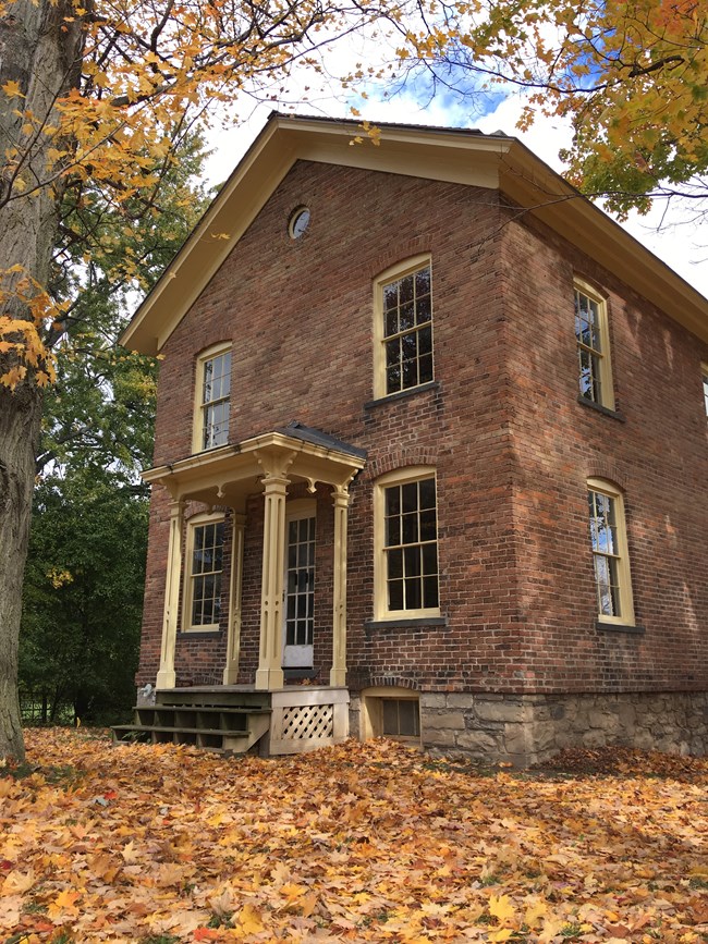 Brick home with small columns in front in autumn.