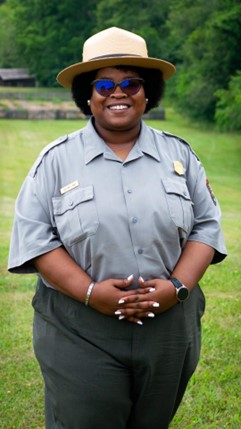 A woman in a ranger uniform standing outdoors.