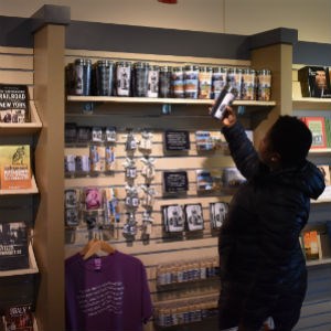 Visitor reaching for coffee mug from bookshelf