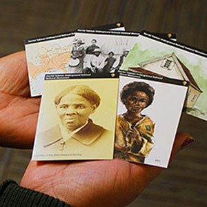 Historical trading cards fanned out in a woman's hands