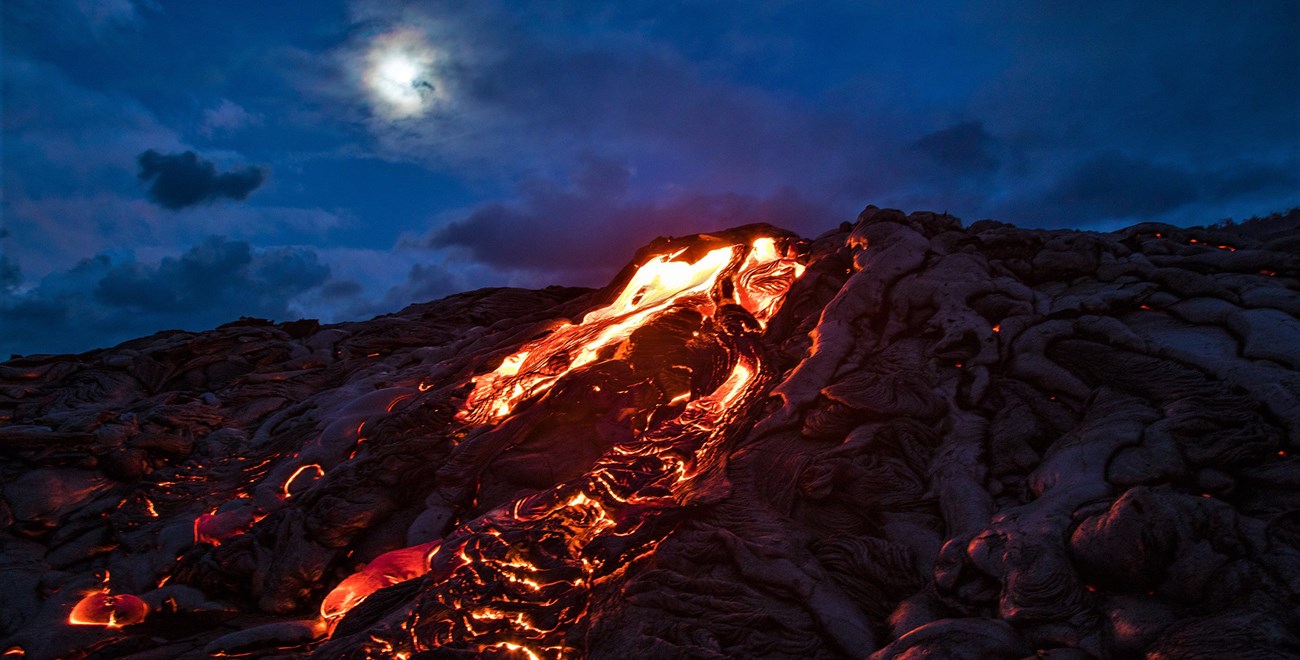 Molten lava underneath a clouded full moon