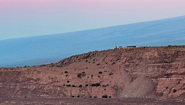 Building sitting on top of the edge of a large crater at dawn