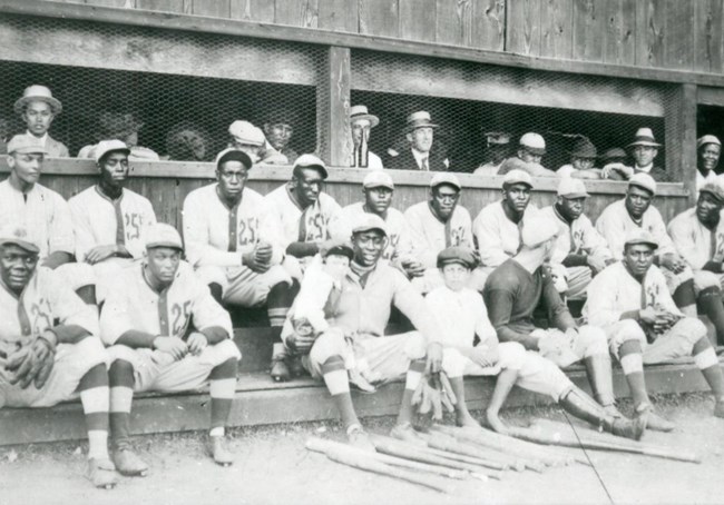 Black and white team photo of an African American baseball team in white uniforms