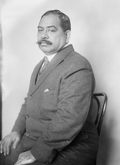 Black and white portrait of a man with a mustache sitting