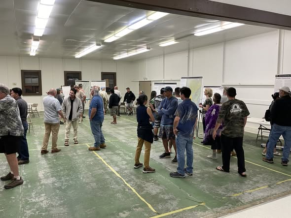 Group of people standing in a meeting hall.