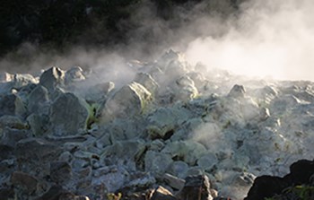 Fumes rising from rocks covered with white crystals