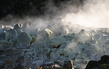 Fumes rising from rocks covered with white crystals