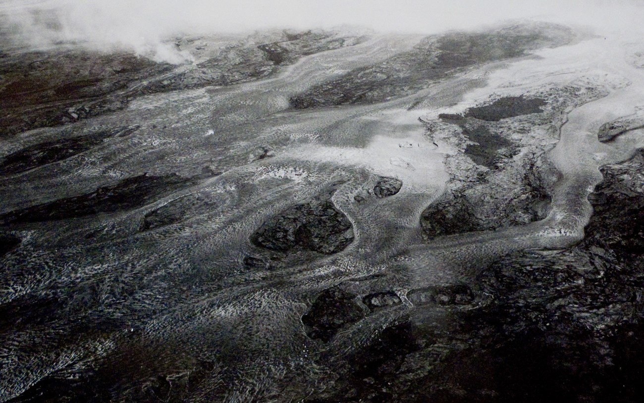 Black and white aerial view of braided rivers of lava