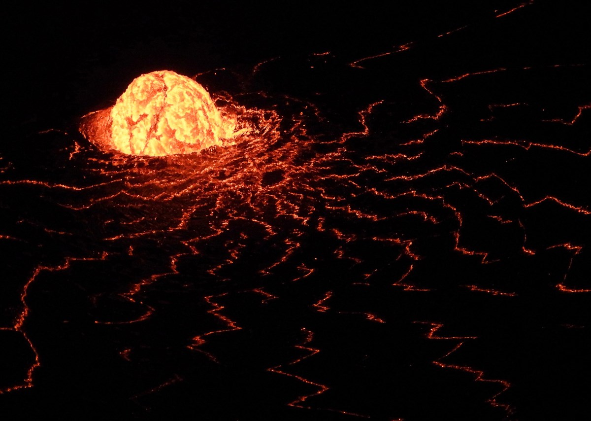 Glowing lava dome fountain in a lake of lava at night viewed from above