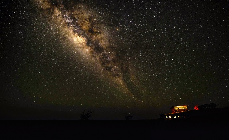960-HAVO_20230713_Milky Way over Uekahuna_J.Wei Milky Way galaxy shines bright with a building lit within below